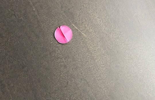 A pink sticker placed over my phone's camera in a Munich nightclub